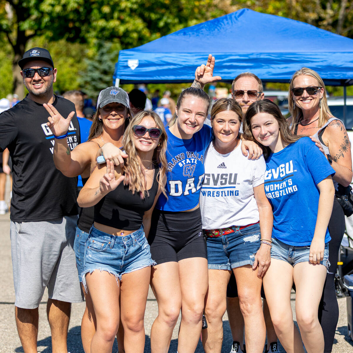 Students and their family members smile for the camera at a Family Weekend Tailgate event